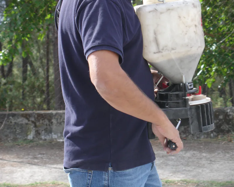 Operario con abonadora manual